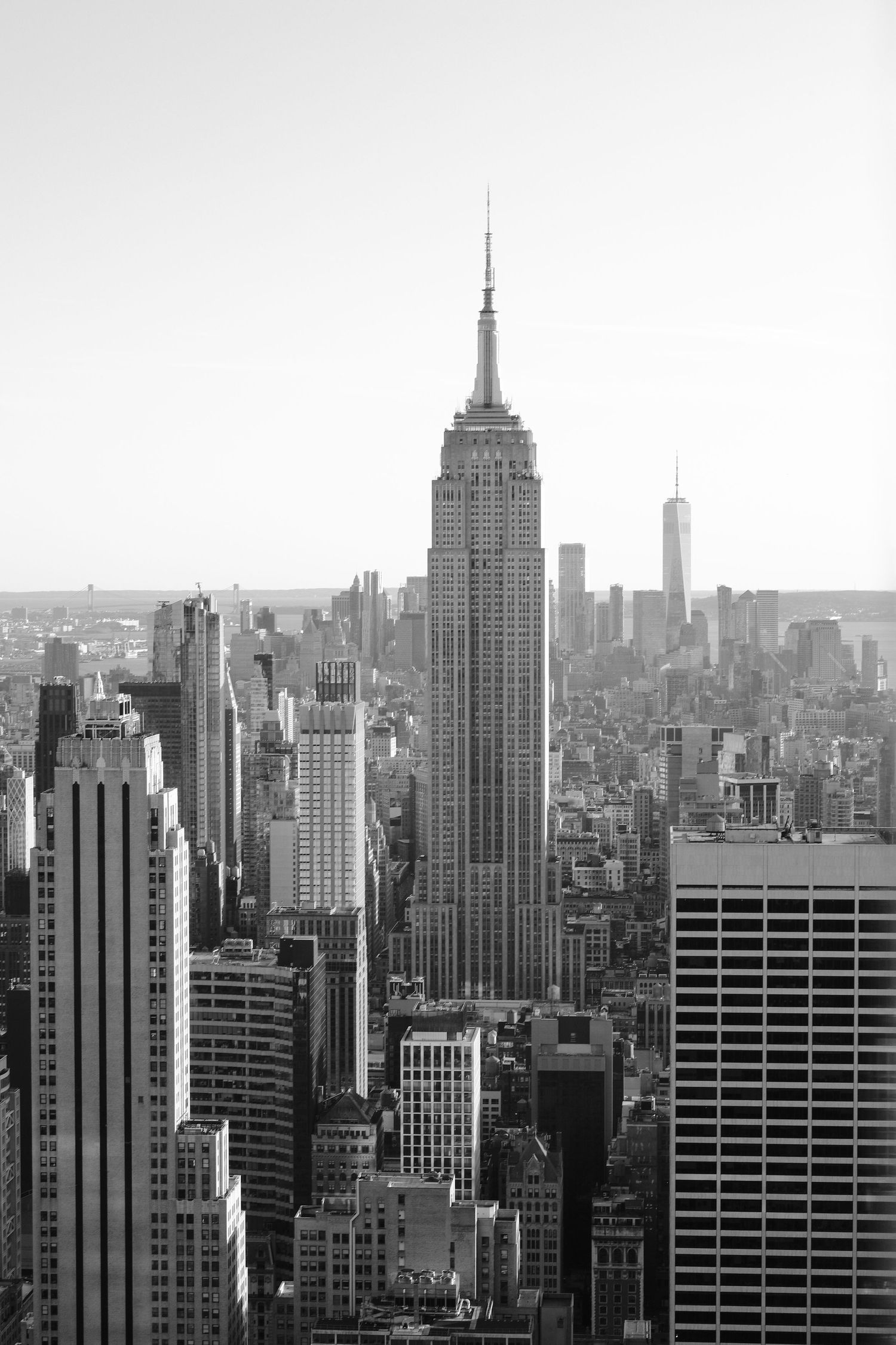 Black and white cityscape of Manhattan with Empire State Building prominently featured.