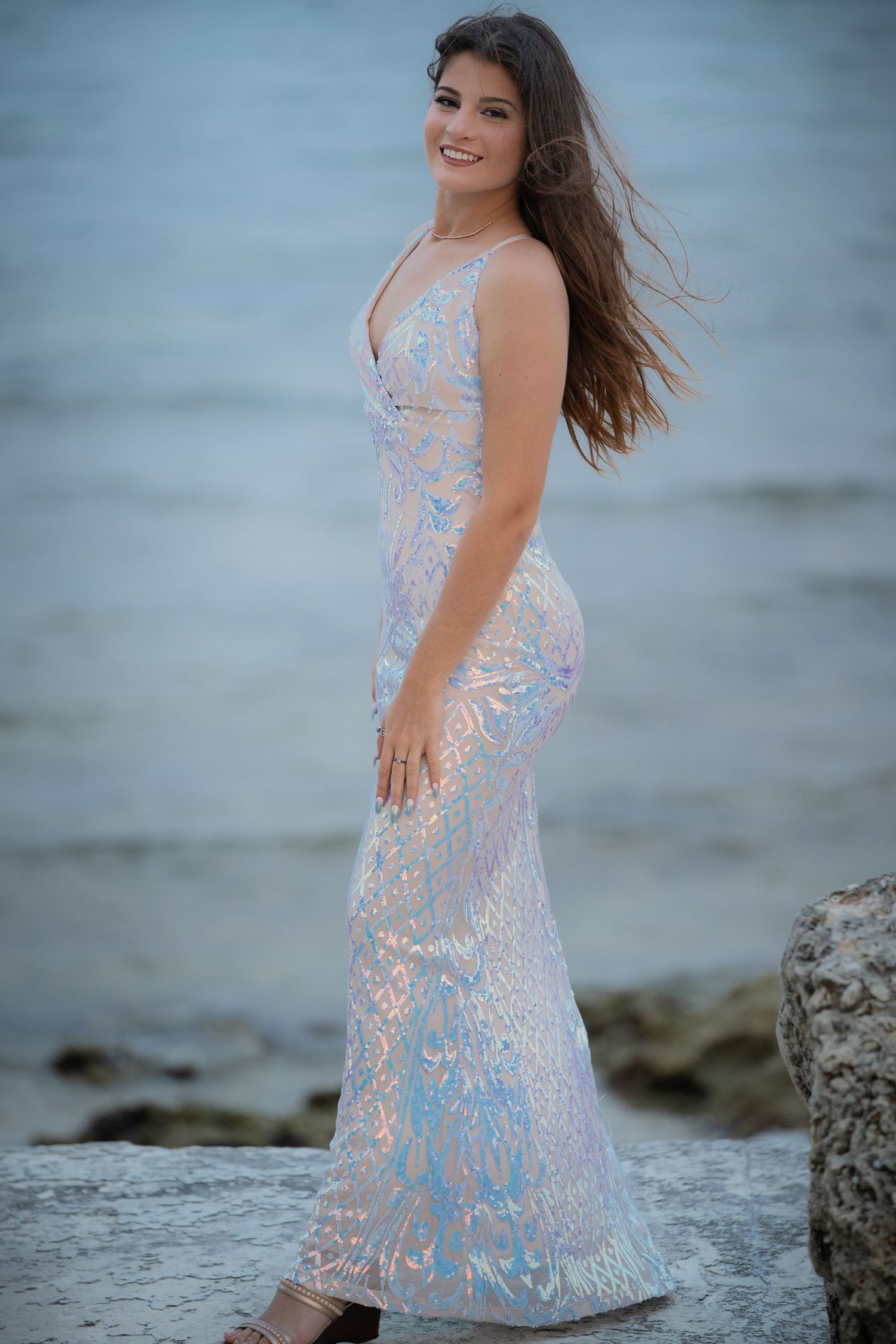 Elegant evening gown in pale blue and blush tones photographed at seaside.