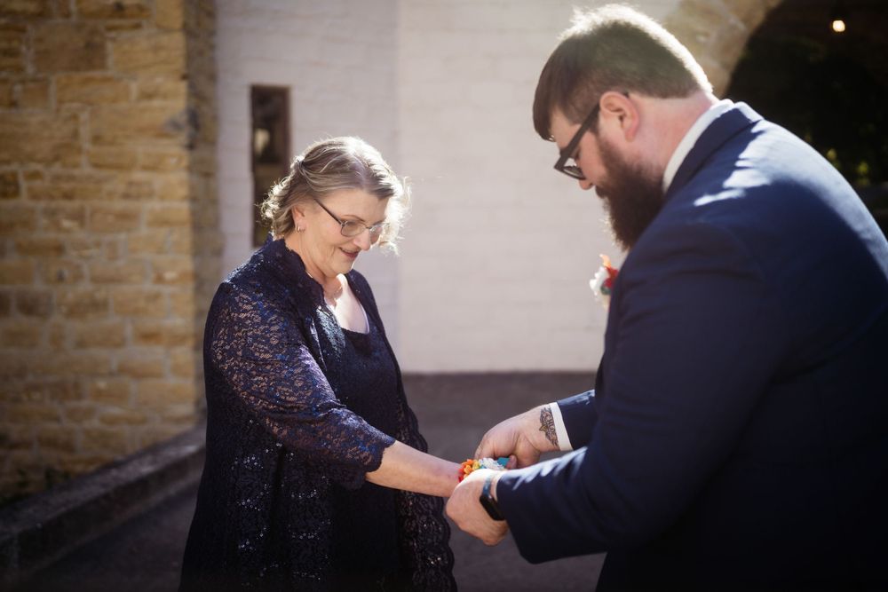 A tender moment shared during a wedding ceremony outside a brick building.