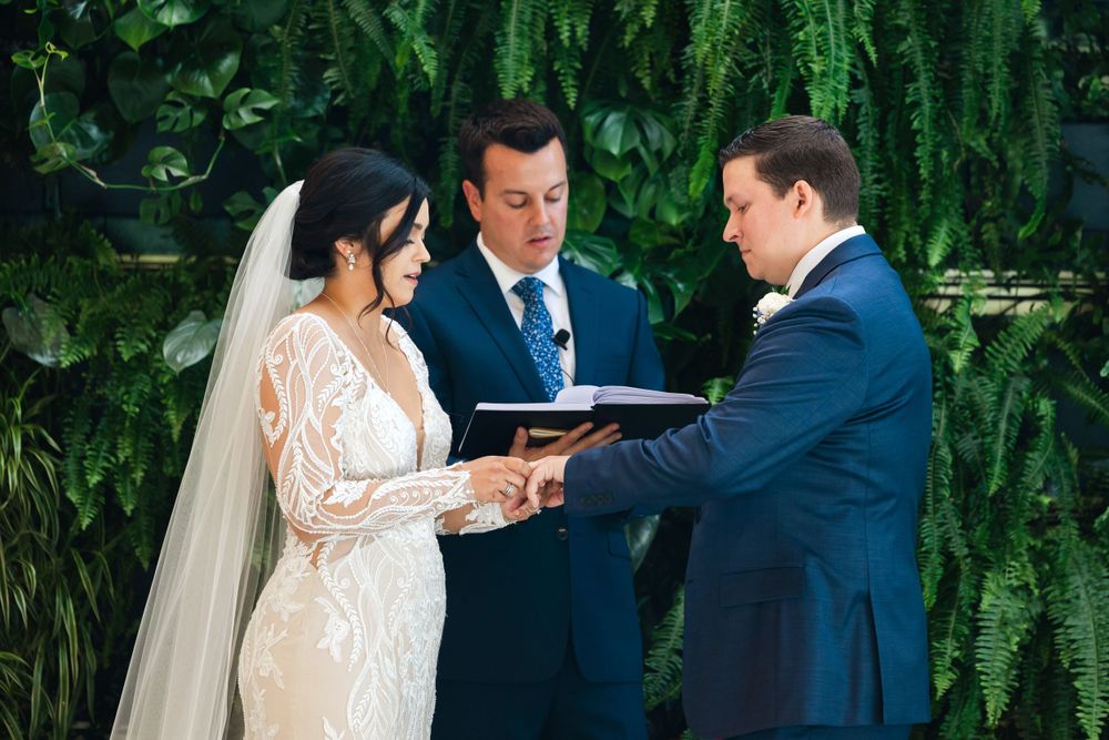 Bride and groom exchange rings during wedding ceremony at Jorgensen Farms in Westerville, Ohio.