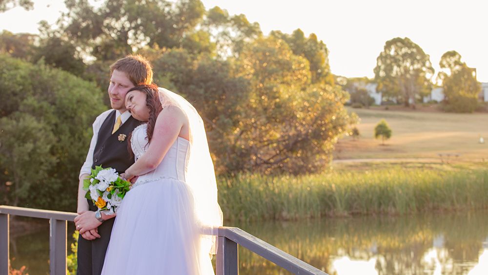 Scenic outdoor wedding portraits taken near a serene lake at golden hour.