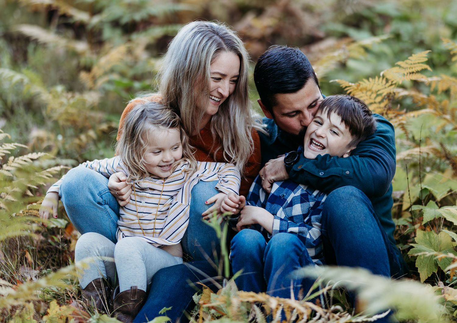 A family laughing and smiling in the grass
