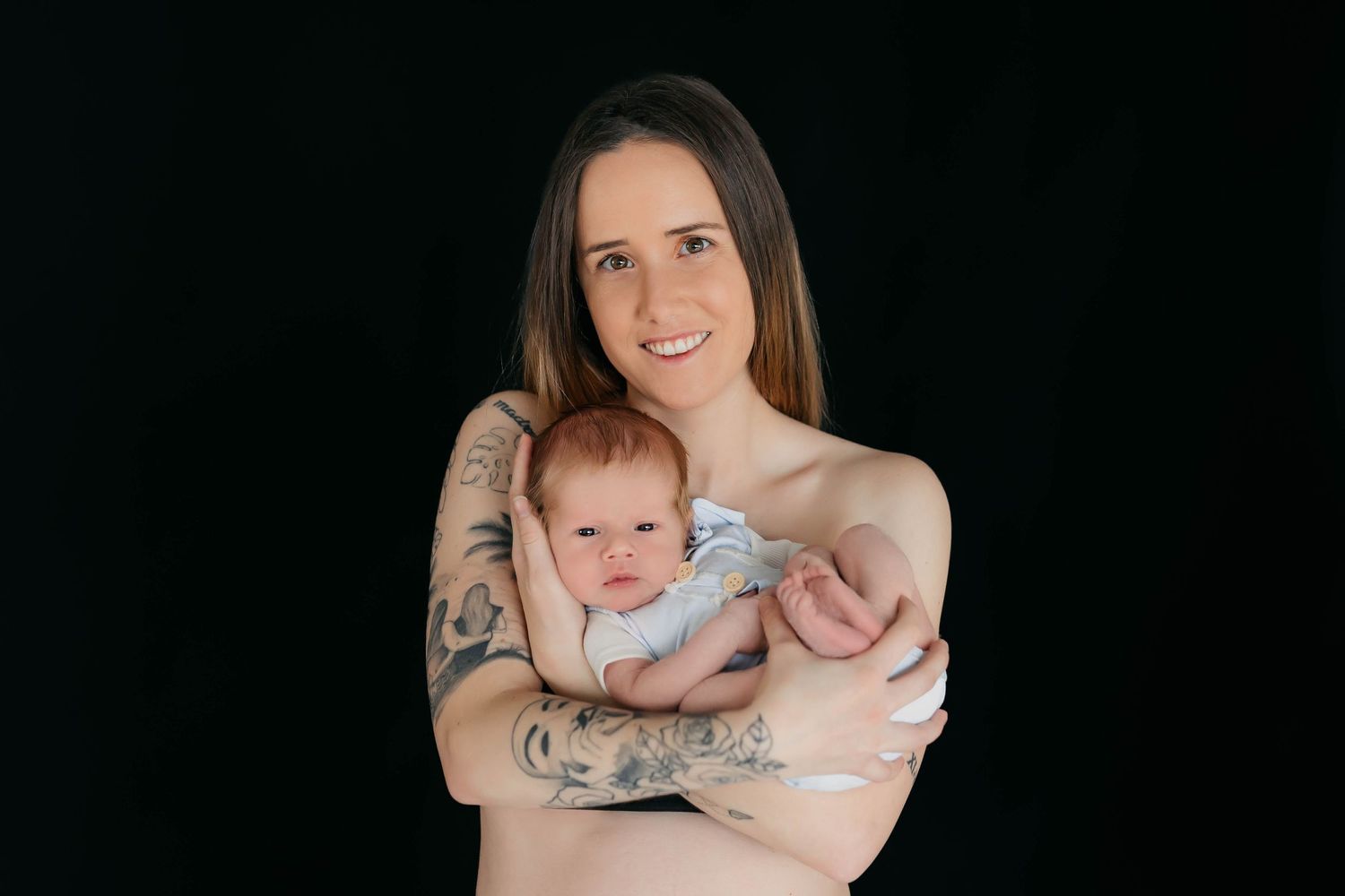 Retrato de un recién nacido en los brazos de su madre durante una sesión de fotos.