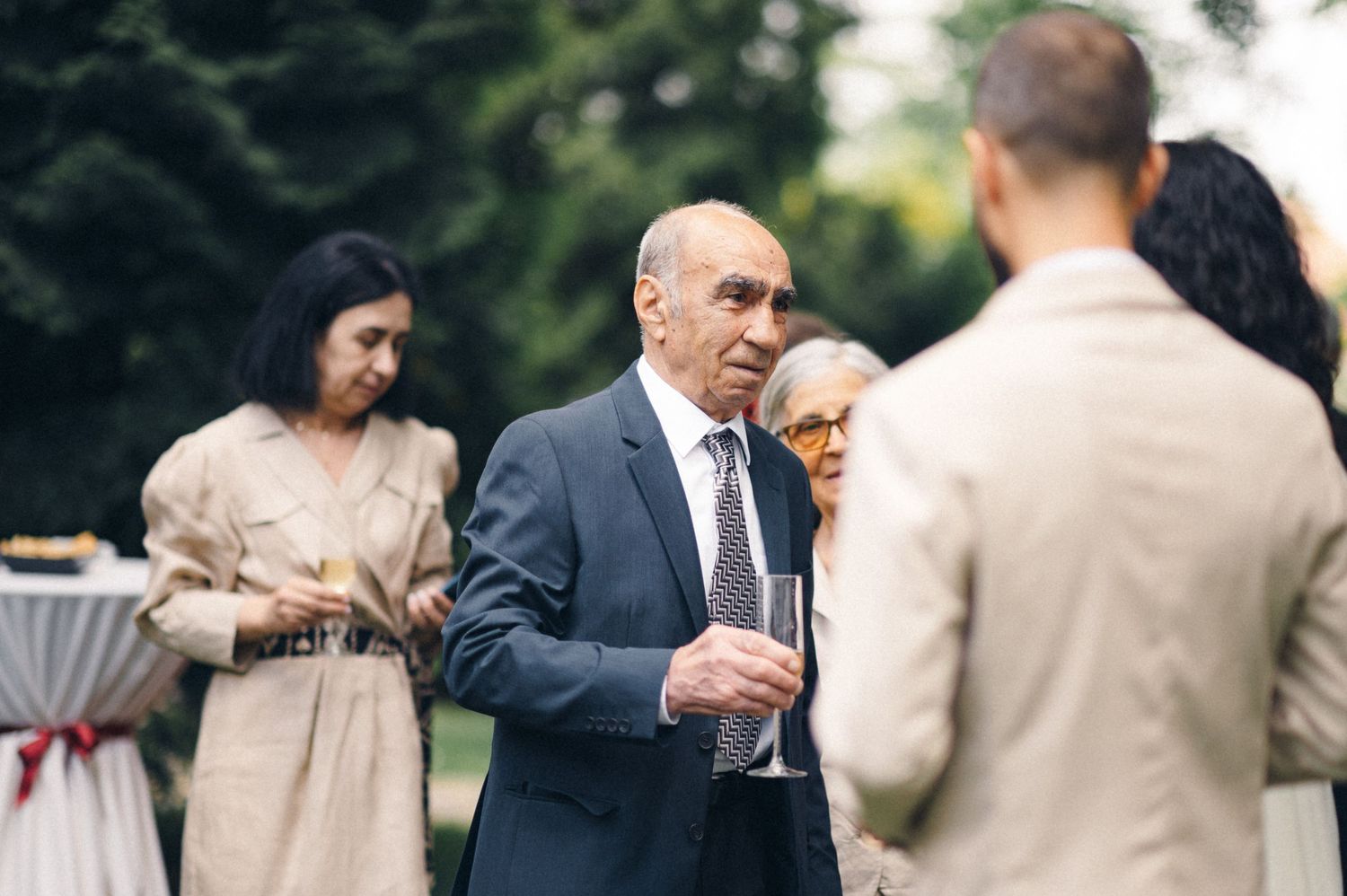 Wedding guests socializing during outdoor cocktail reception with drinks.
