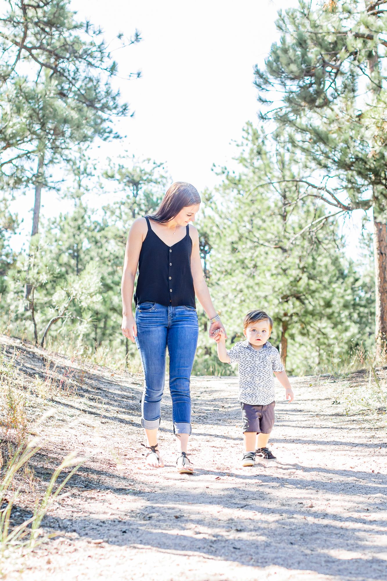 Mom walks with her toddler boy down the trail in Black Forest, Colorado.