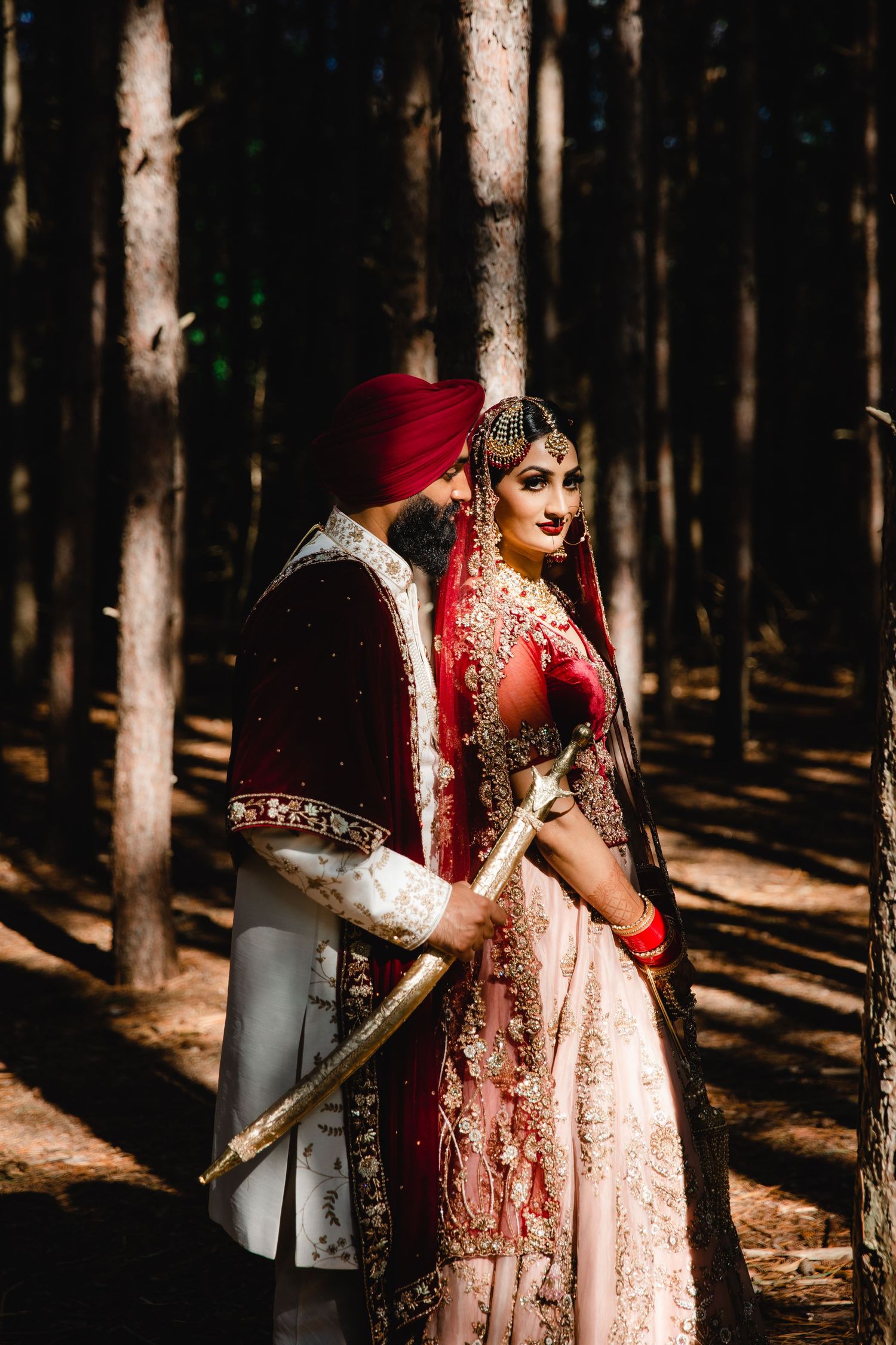 Traditional South Asian wedding attire captured in a mystical forest setting with dramatic lighting.