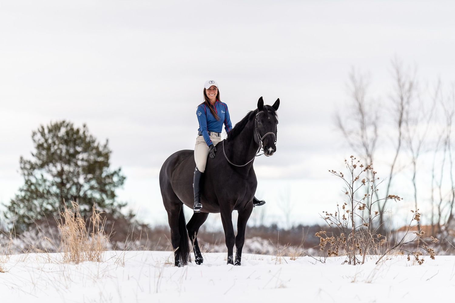 Snowy landscape portrait with horse and rider in the middle