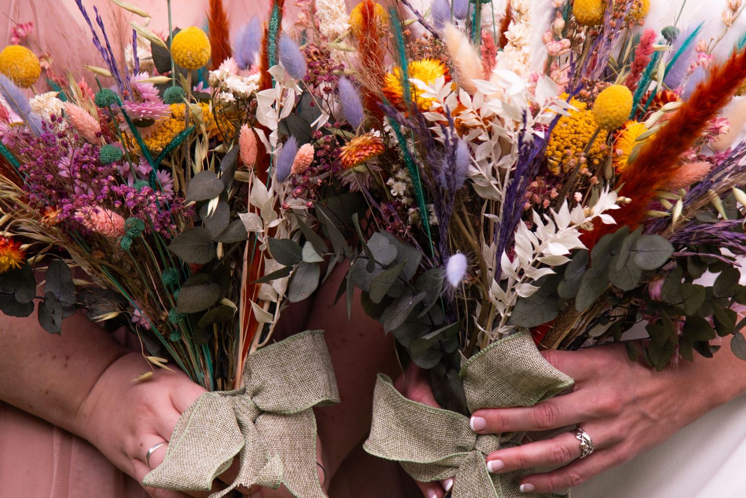 Vibrant fall-colored wedding bouquet with orange, yellow and pink flowers.