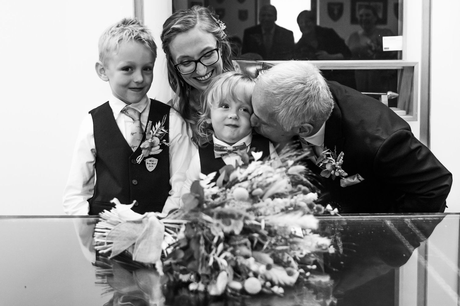 Black and white candid moments from indoor wedding celebration.
