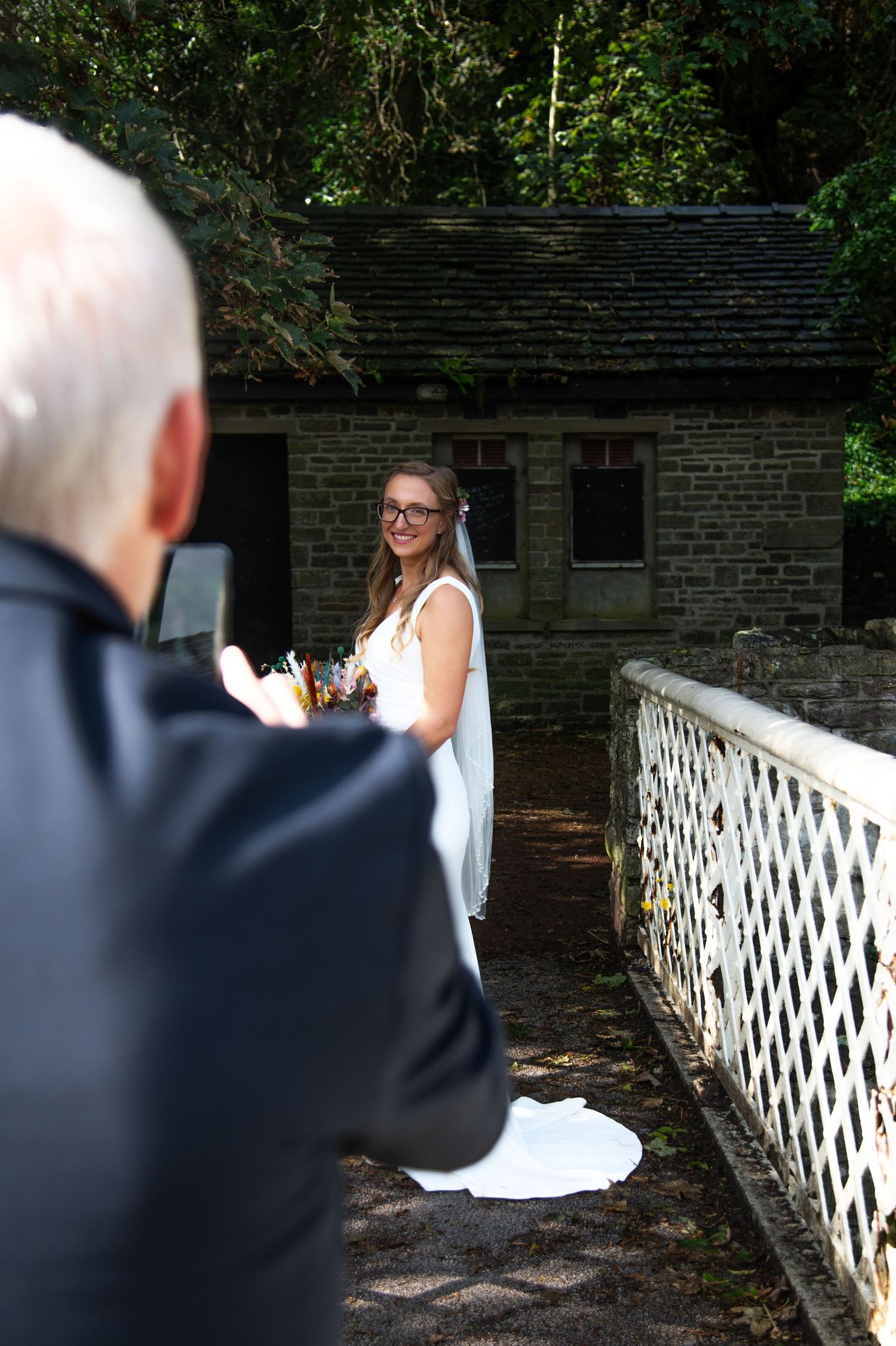 A couple on a white lattice bridge during their wedding photo session.