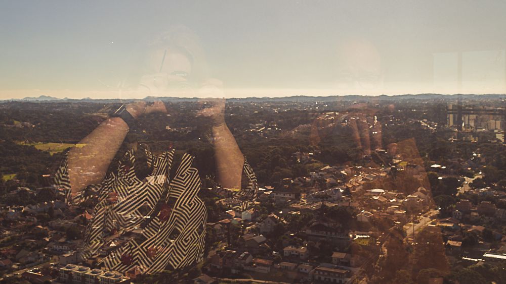 Curitiba city skyline reflected in glass windows, photographed by Piret Victoria Ribas.