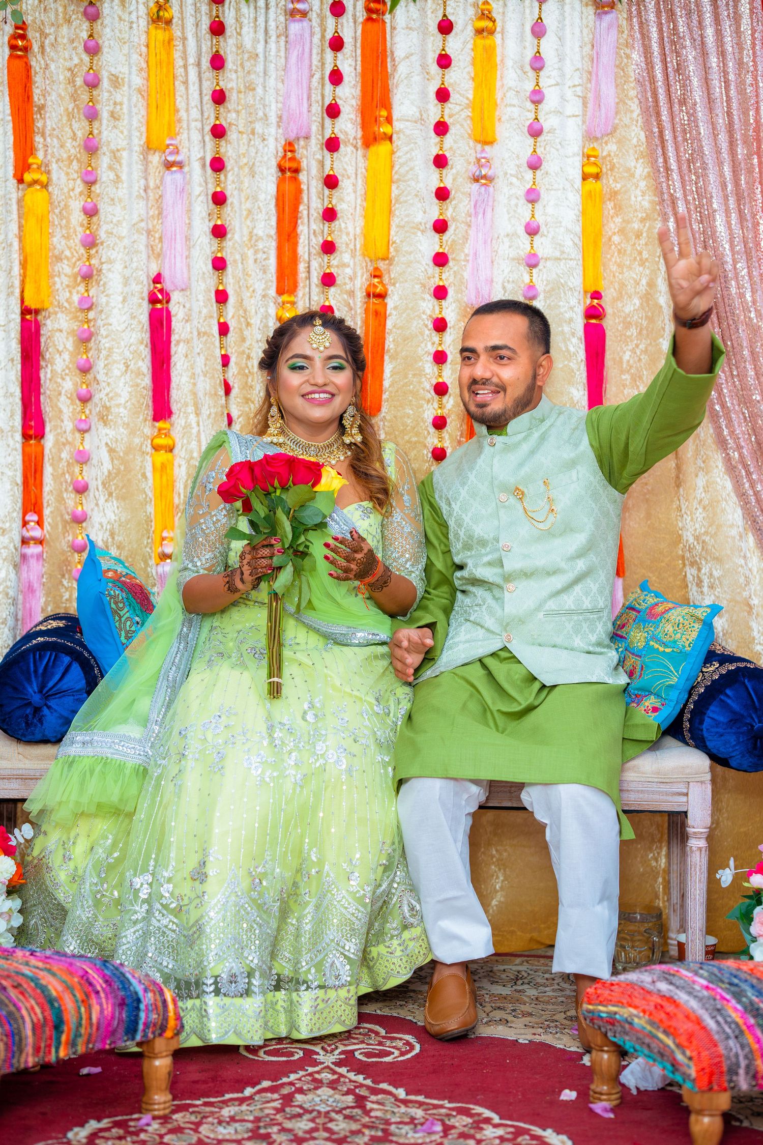 Newlyweds in matching green attire celebrate during wedding ceremony with roses.