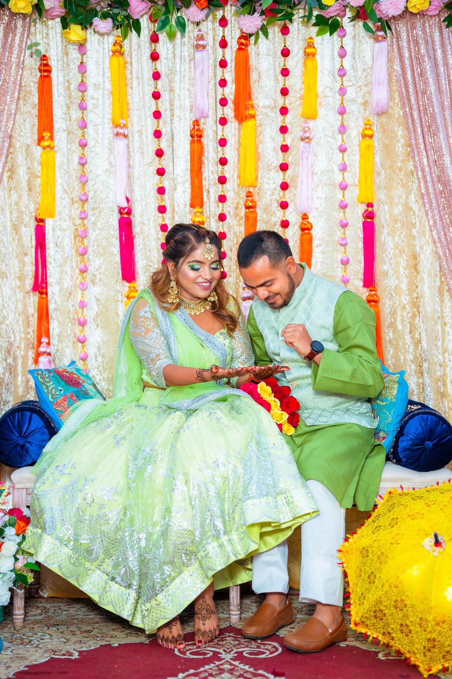 Couple shares intimate moment in matching green outfits during wedding ceremony.