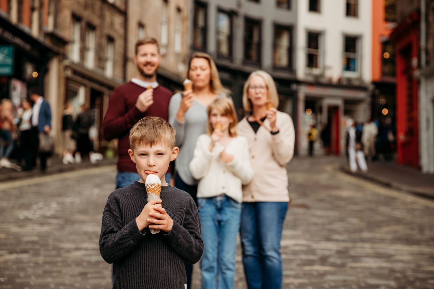 A candid street scene with people enjoying a moment together on a cobblestone street in a historic city.