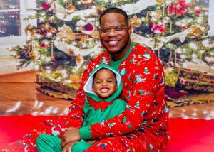 Holiday portrait with matching Christmas pajamas in front of decorated tree backdrop.