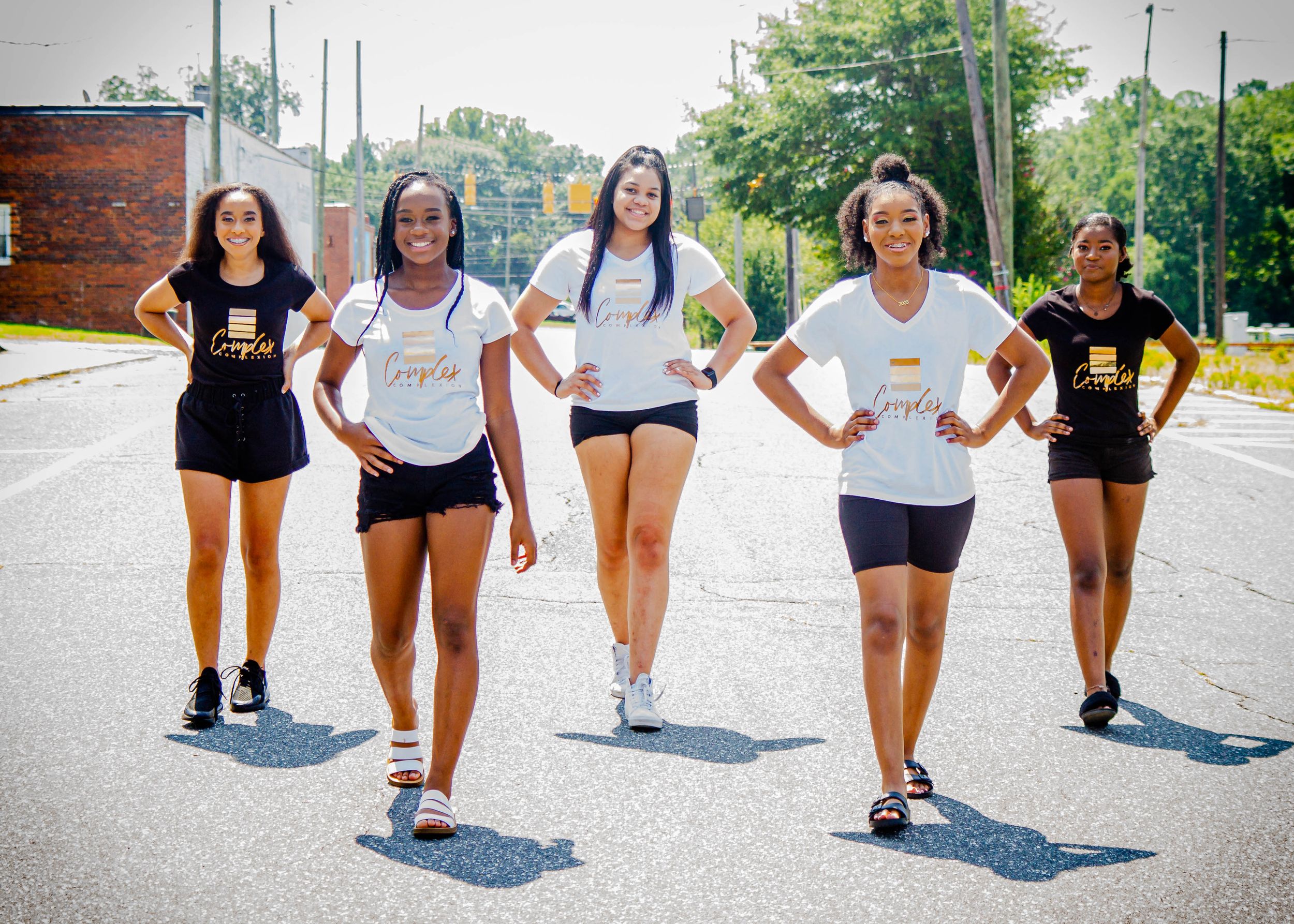 Group of athletes in workout clothes walking together on outdoor path.