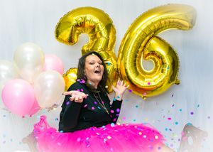 Birthday celebration with gold number 36 balloons, pink tulle, and falling confetti.