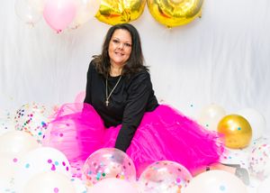 Festive portrait with pink tulle skirt, gold 36 balloons, and scattered party decorations.
