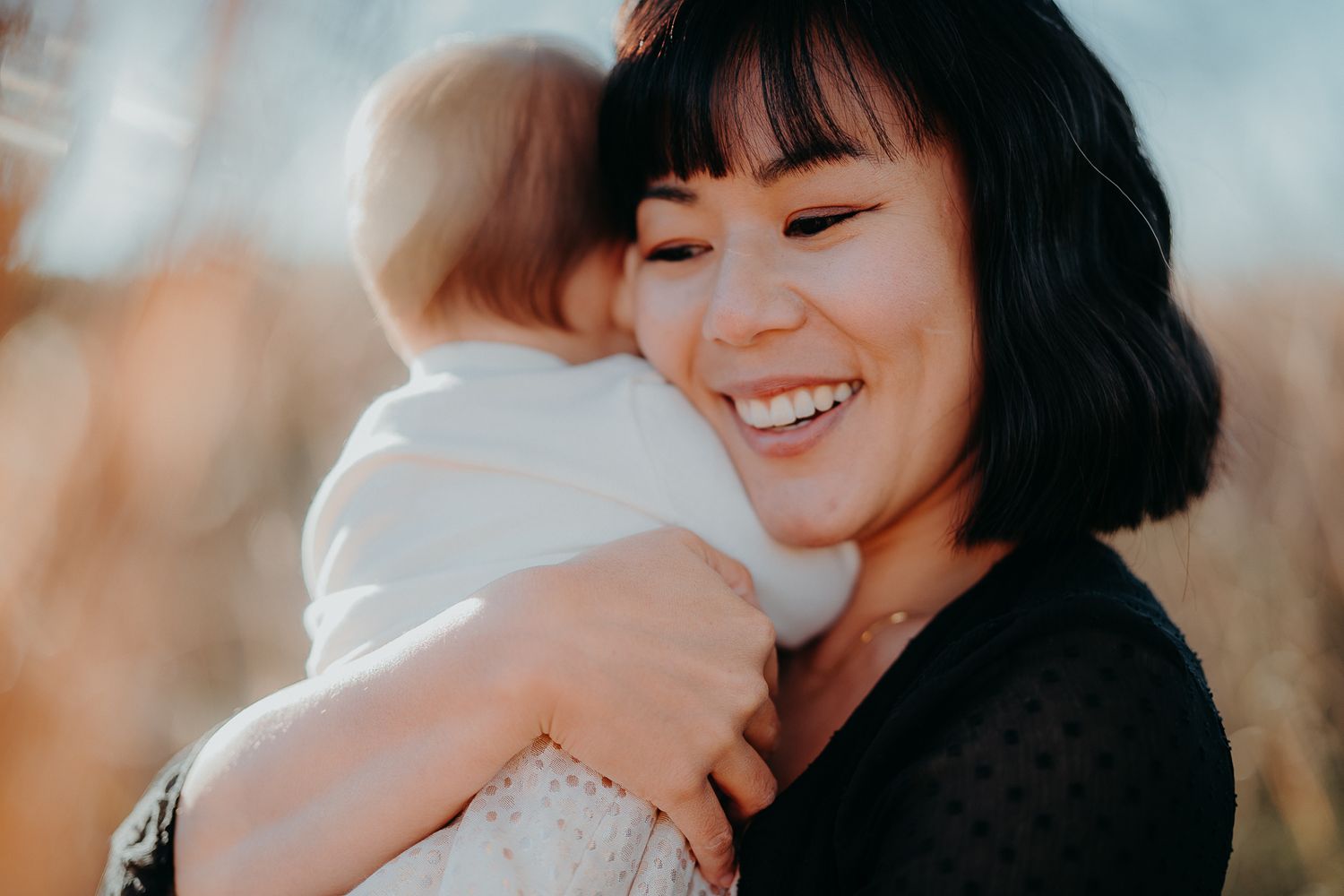 Joyful outdoor portrait showing warm embrace between parent and child.