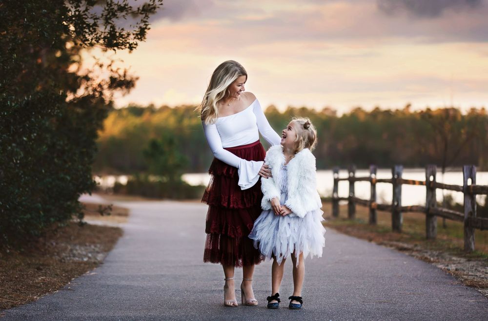 Mother and daughter sharing tender moment on path during sunset.