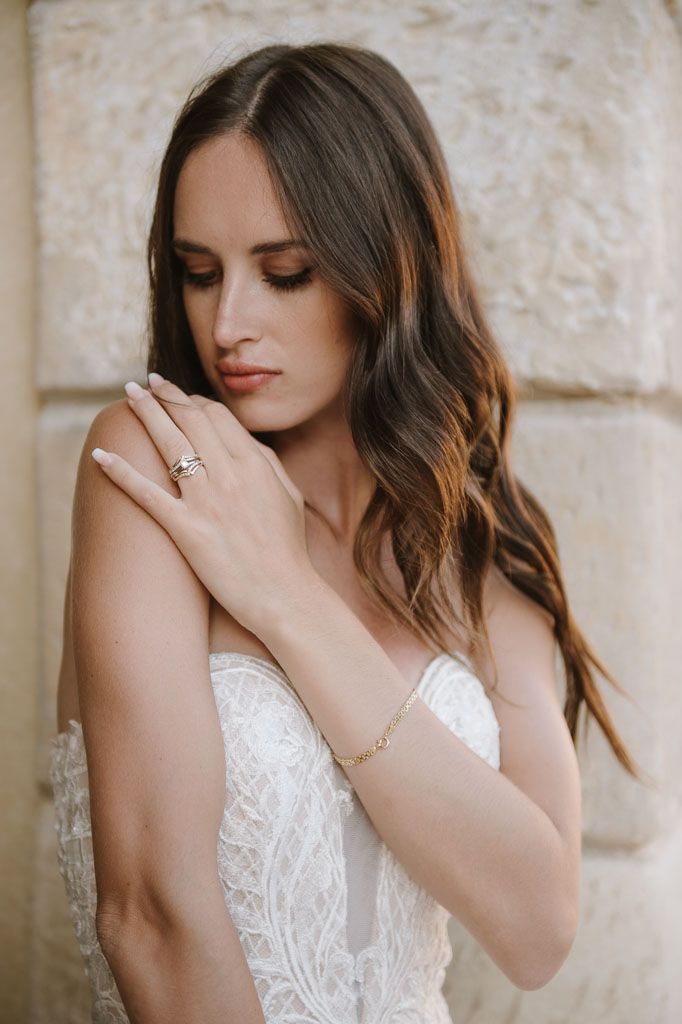 Elegant bridal portrait highlighting intricate jewelry and romantic wedding dress details.
