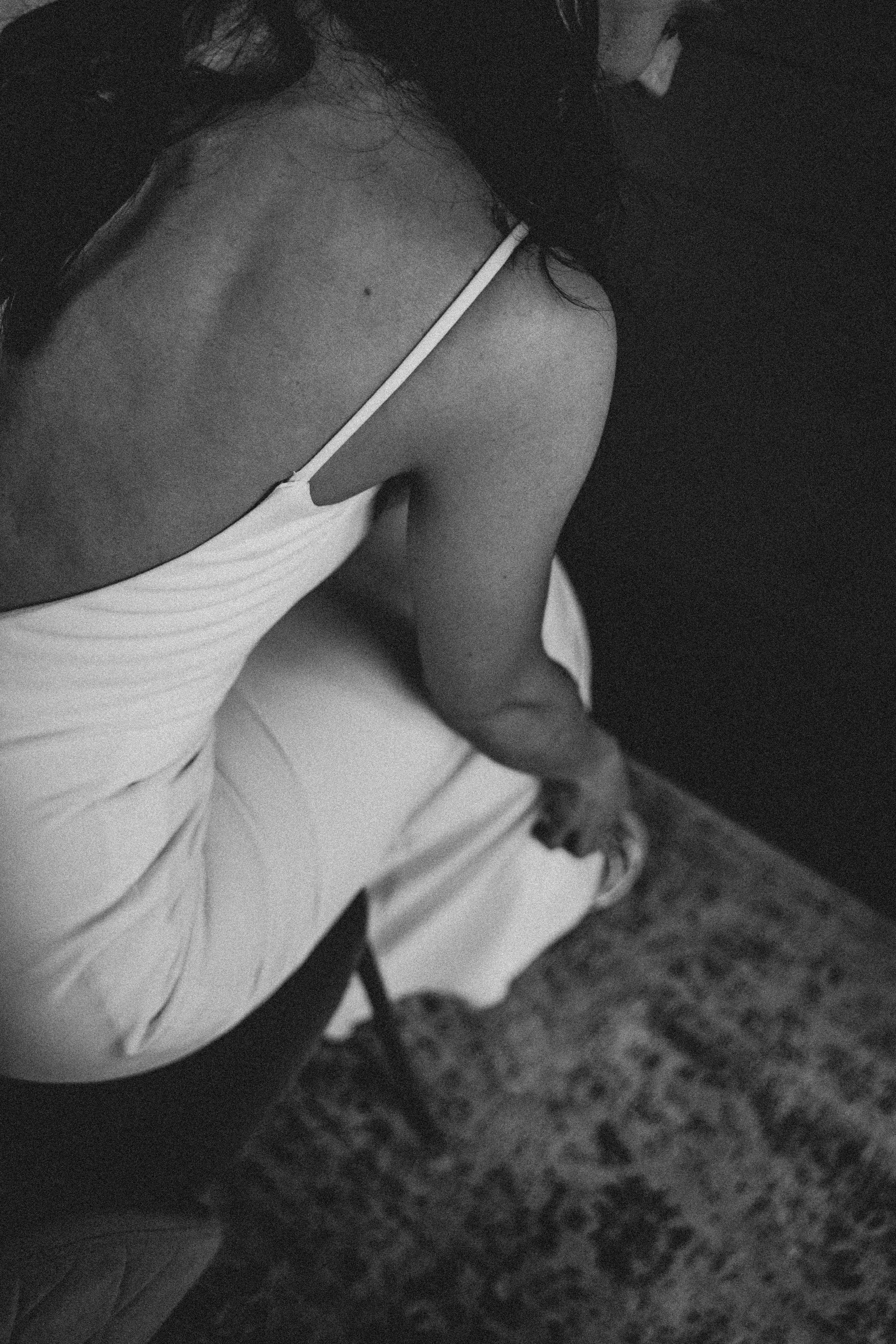 Black and white photo showing details of a sleek wedding dress.