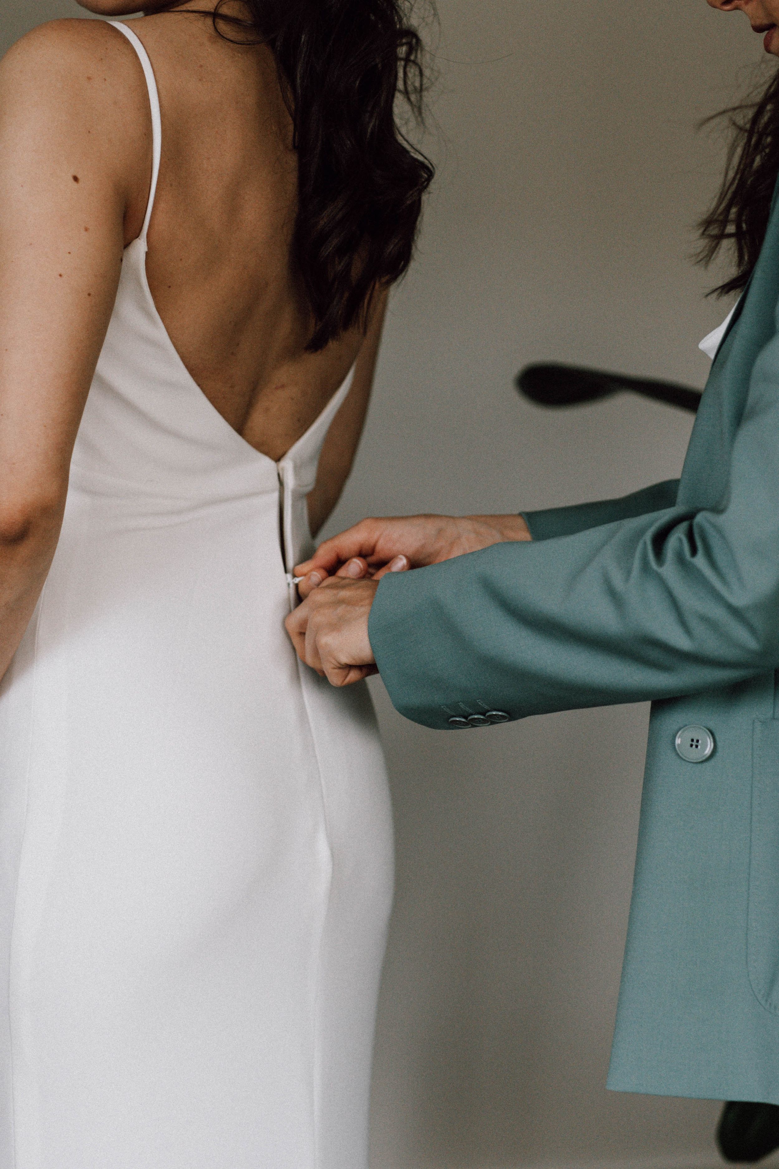 Wedding dress being adjusted with delicate attention to detail.