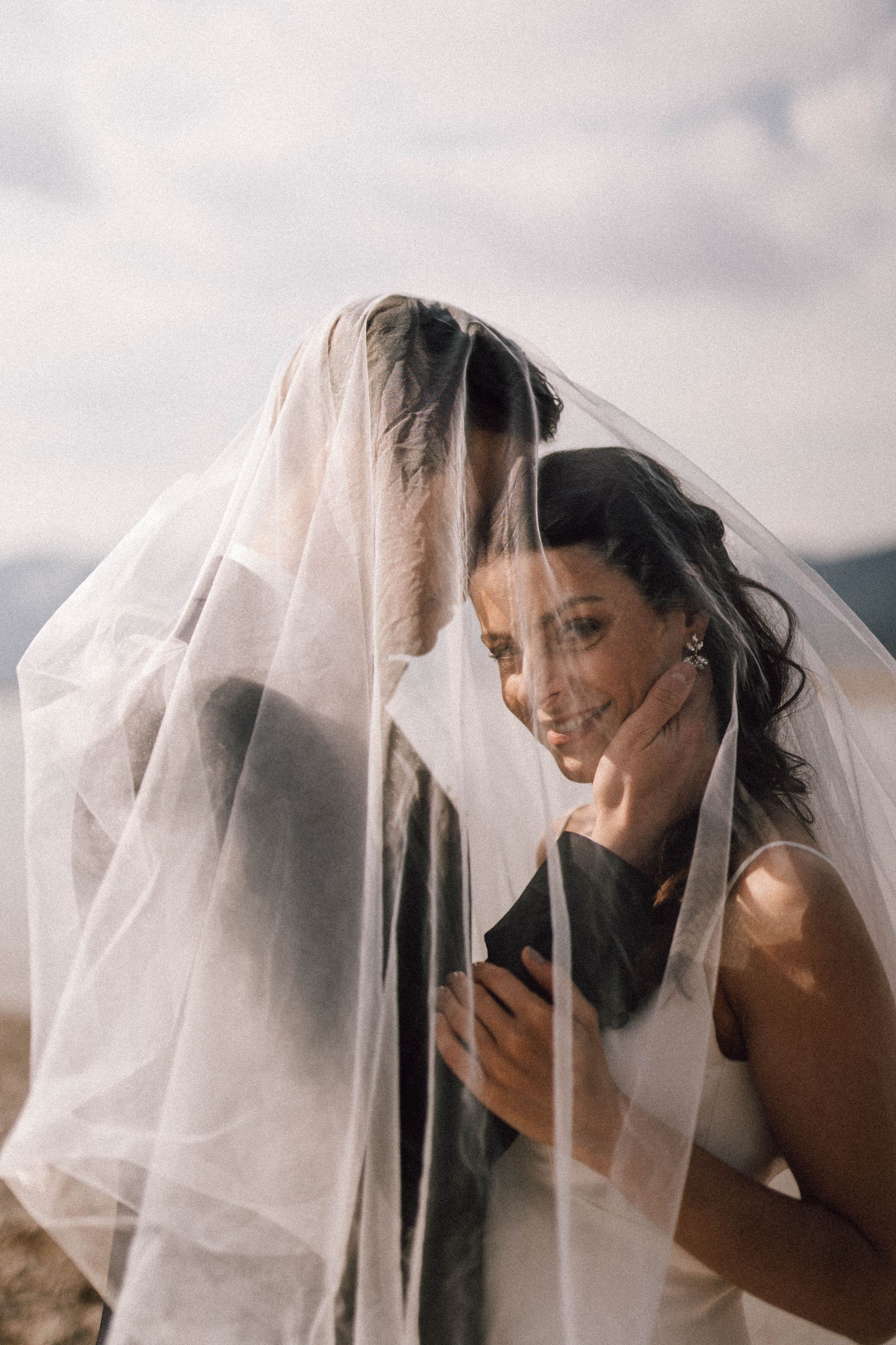 Artistic black and white portraits of a bride behind her delicate wedding veil.