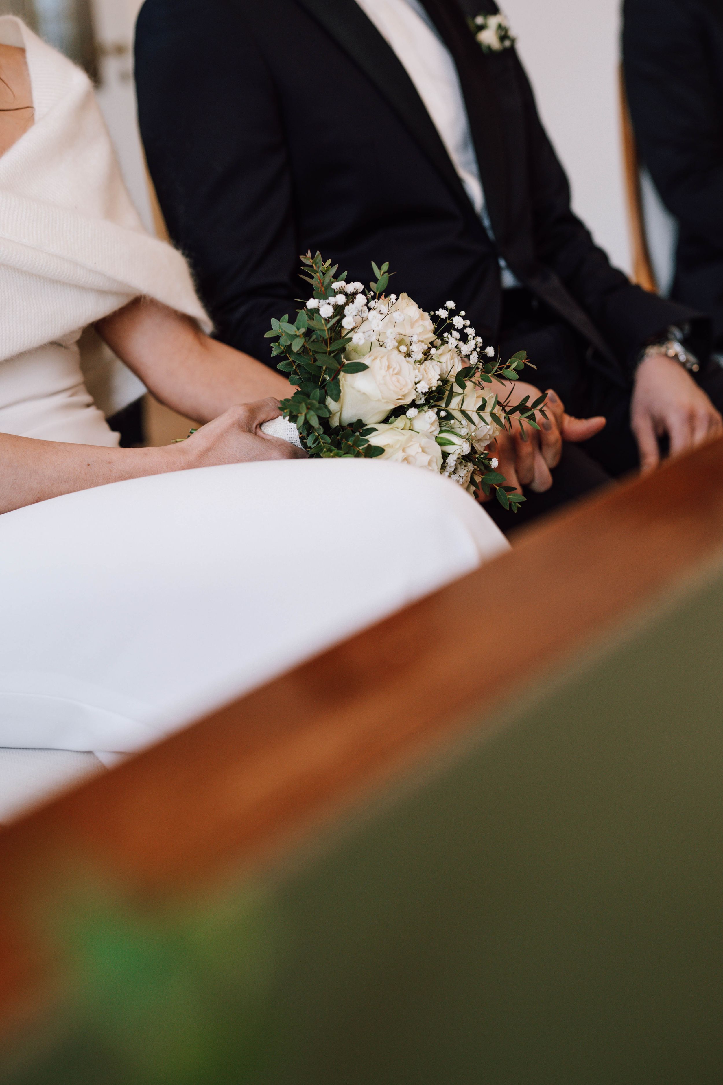 Intimate wedding ceremony details with flowers and formal attire.