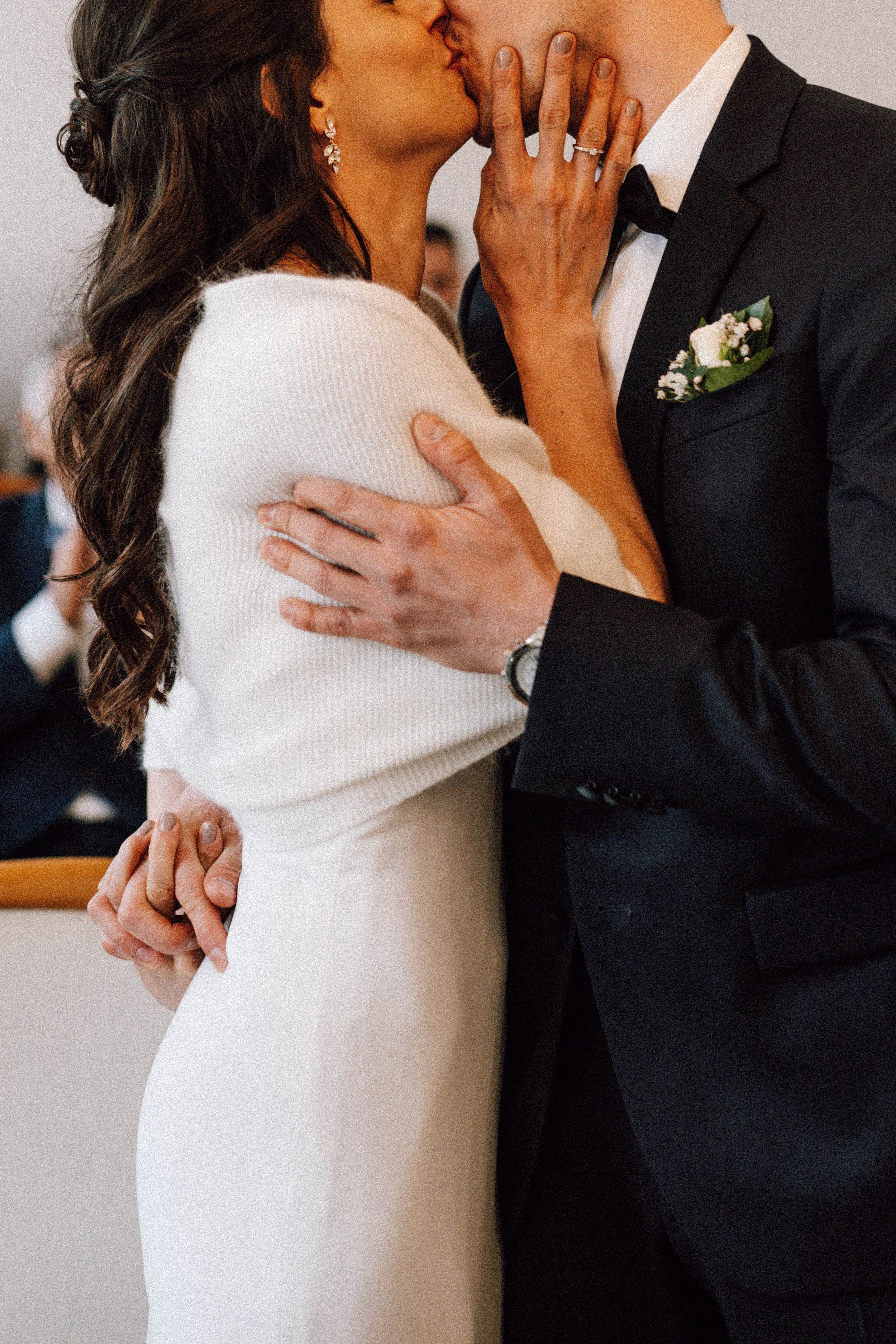 A romantic wedding moment showing a couple embracing in formal attire, with the bride in a white dress and groom in tuxedo.