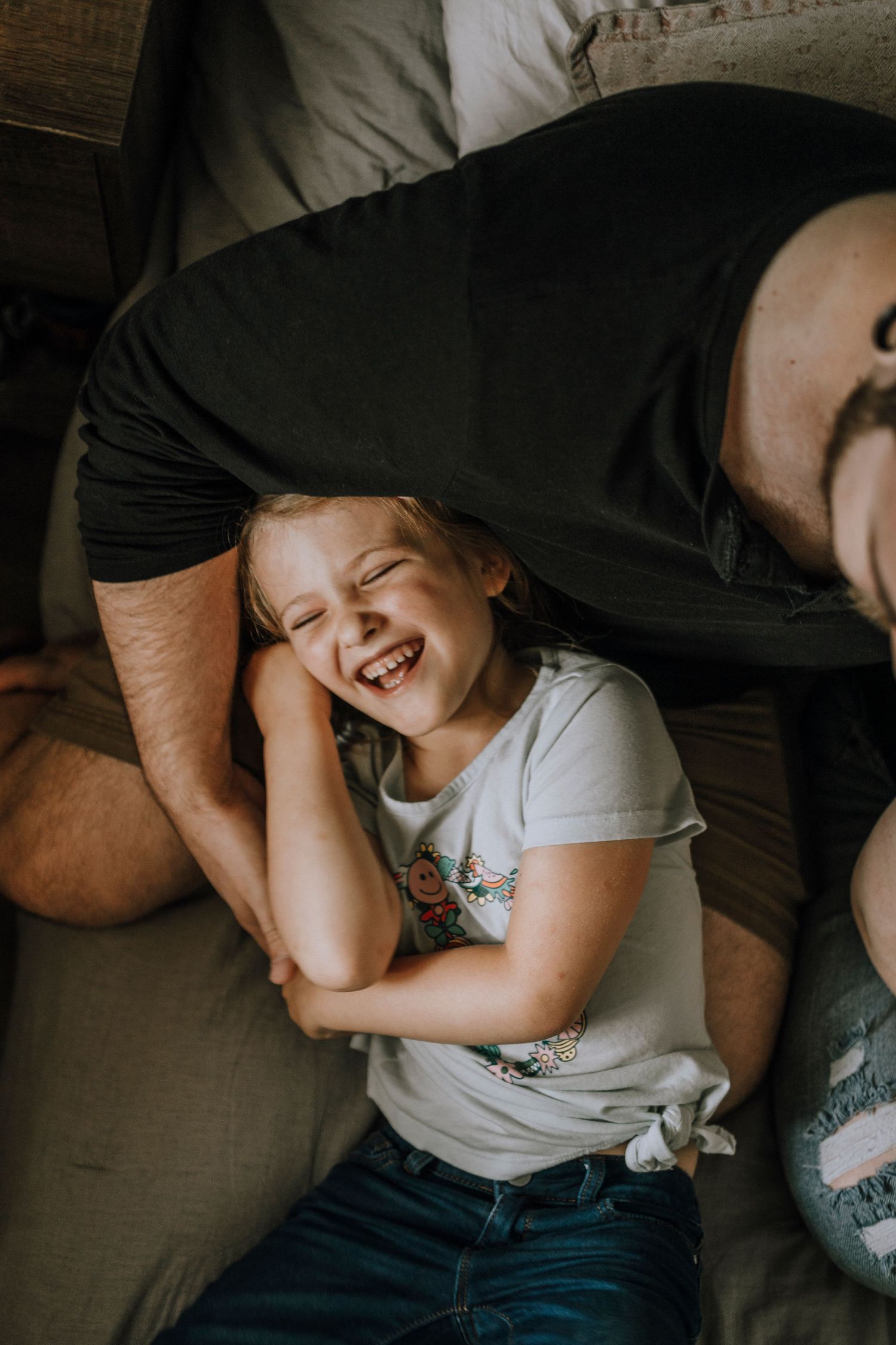 A playful moment of laughter and joy captured during a family photoshoot.