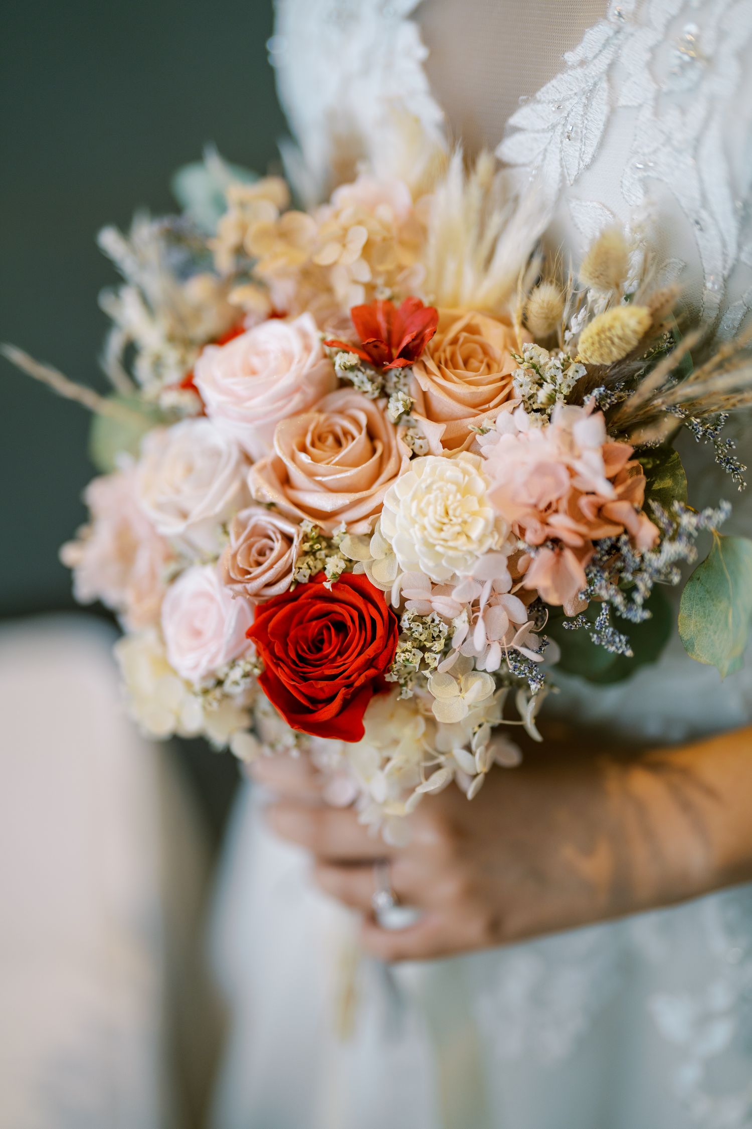 Beautiful wedding bouquet featuring peach, red and white roses with delicate baby's breath accents.
