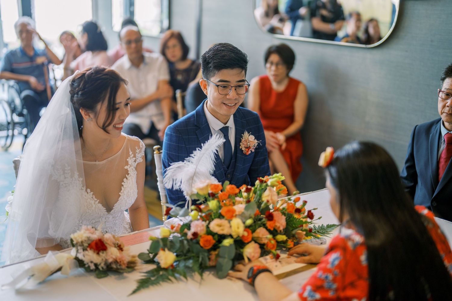 A wedding celebration at a restaurant with a colorful floral centerpiece on the table during a meal service.