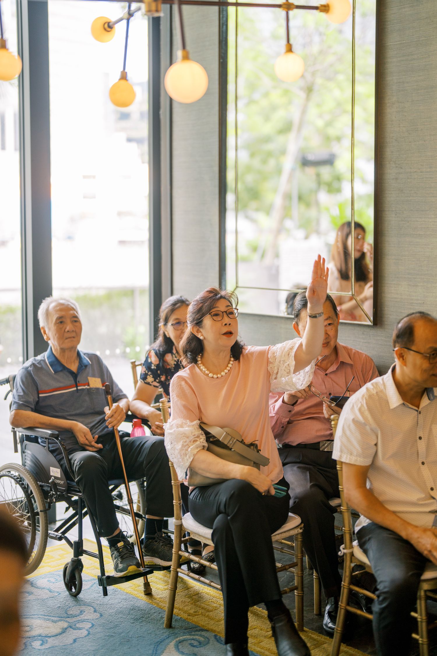 Wedding guests seated in chairs and wheelchairs react enthusiastically during the celebration.