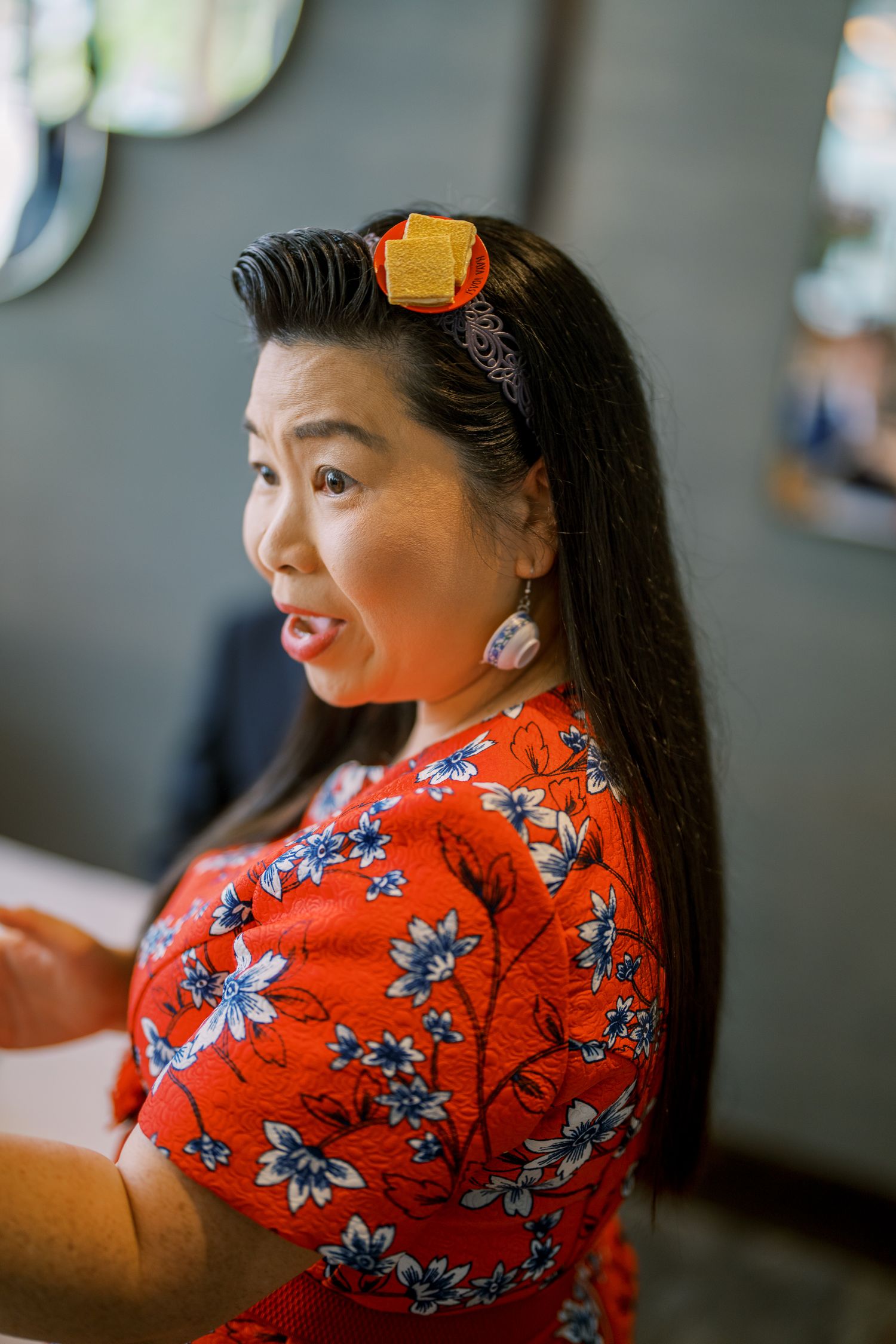 Close-up portrait of someone wearing a bright red floral dress at a wedding event.