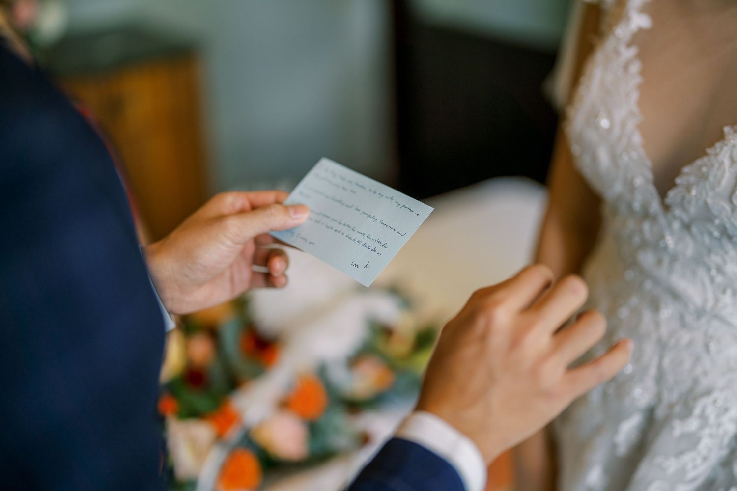 Hands holding wedding ceremony documents during an intimate indoor celebration.