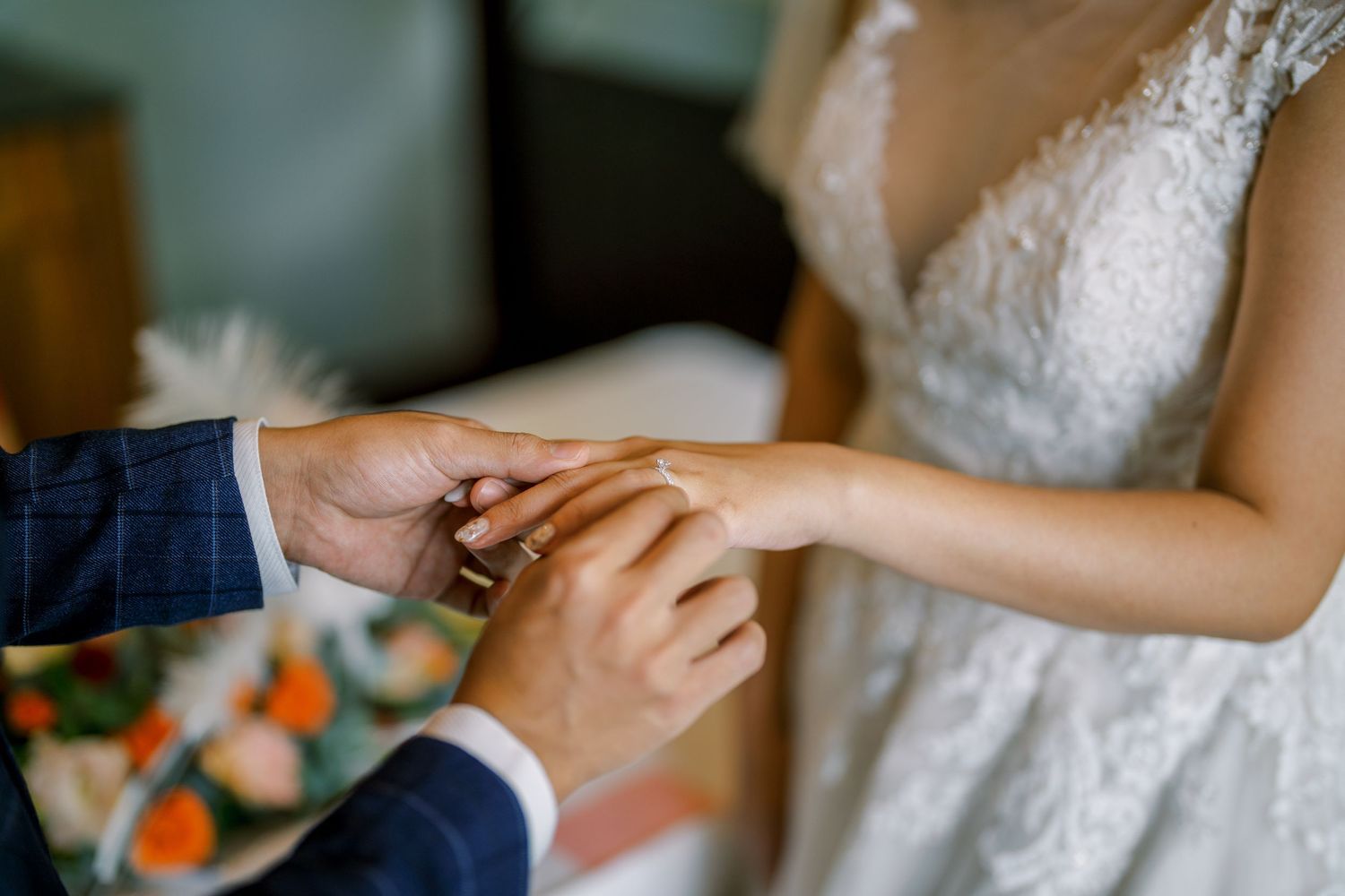 Hands exchanging a small pink card in a formal setting.
