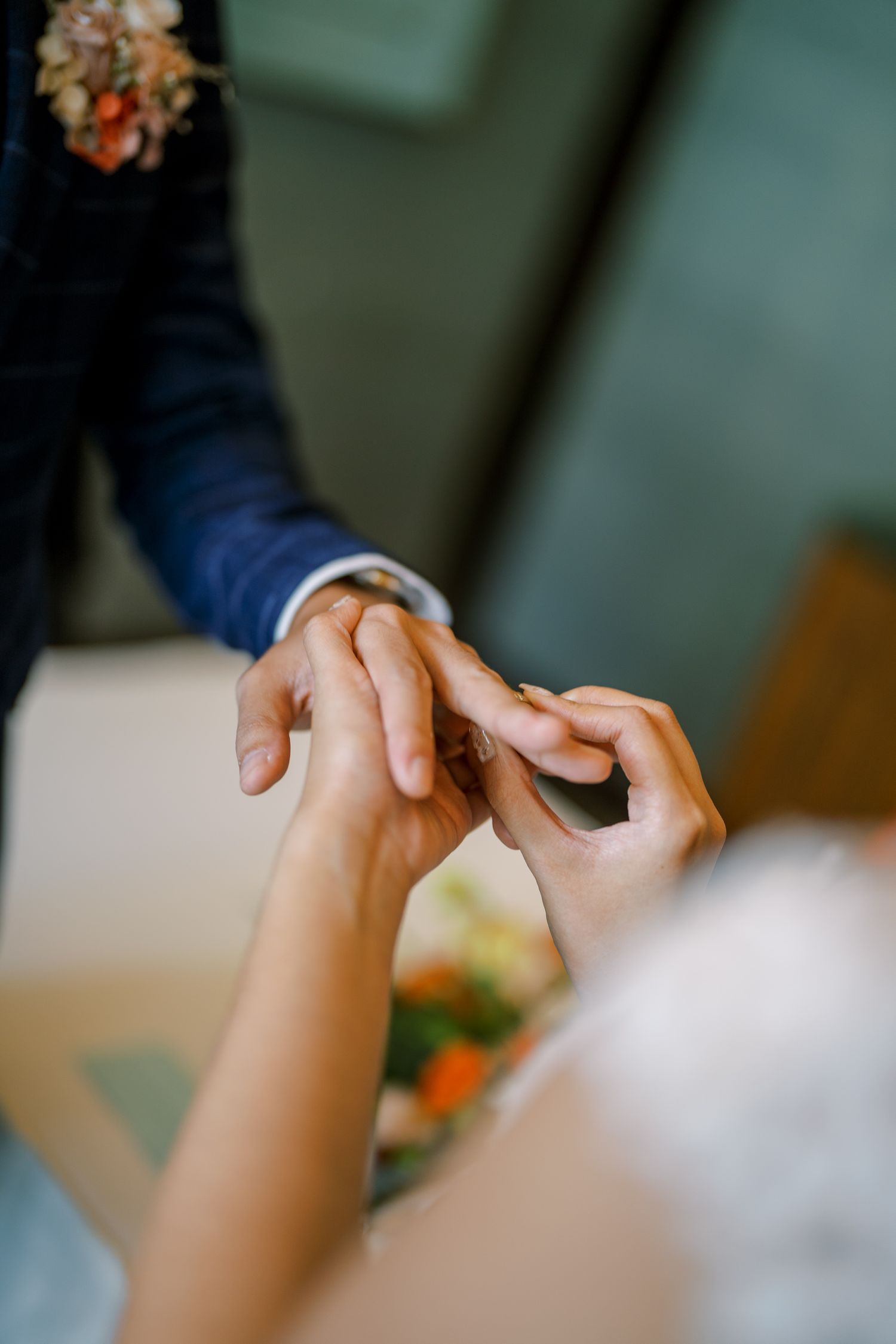 Close-up shot of hands reaching towards each other during a ceremony.