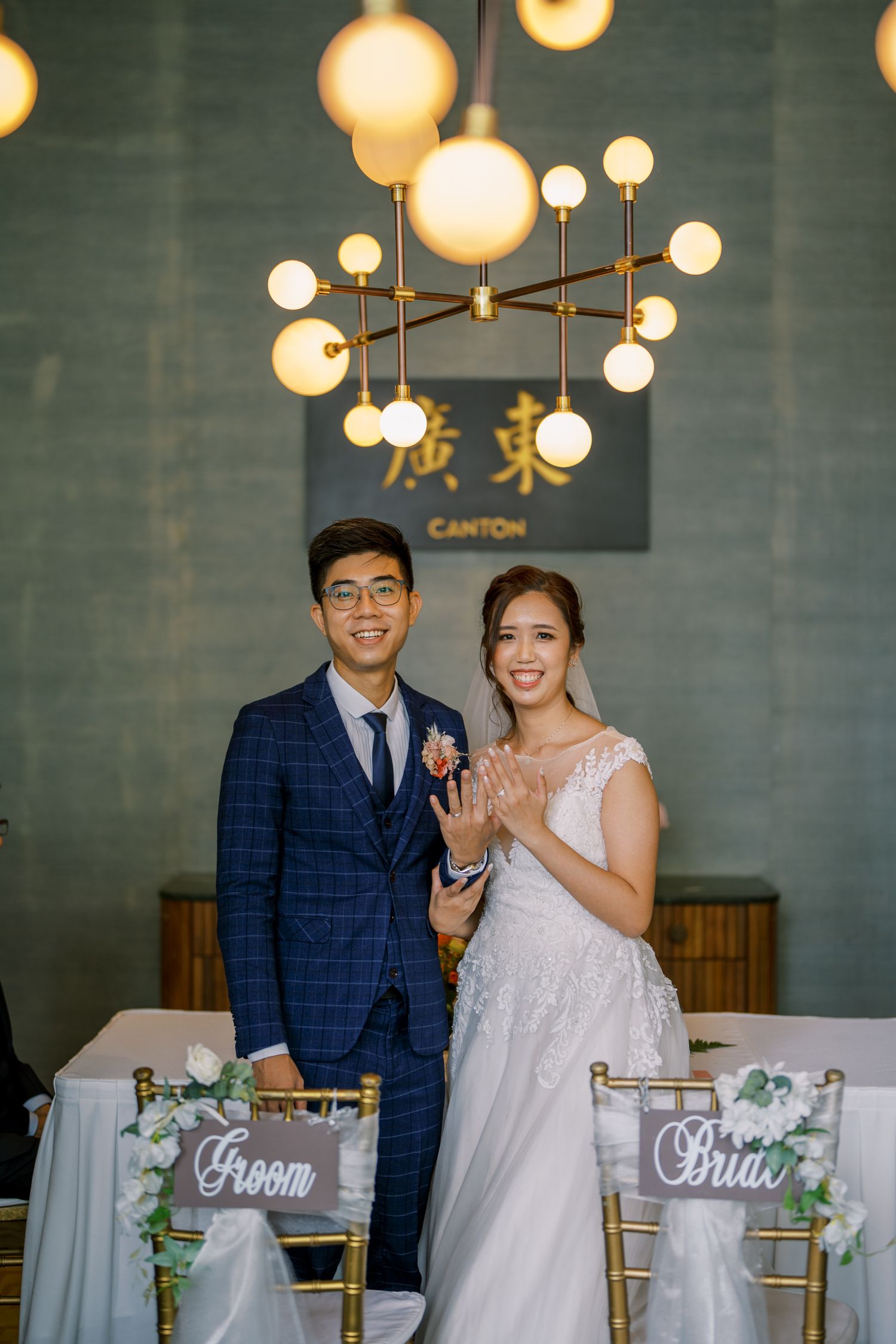 Wedding reception venue decorated with modern lighting and table settings.