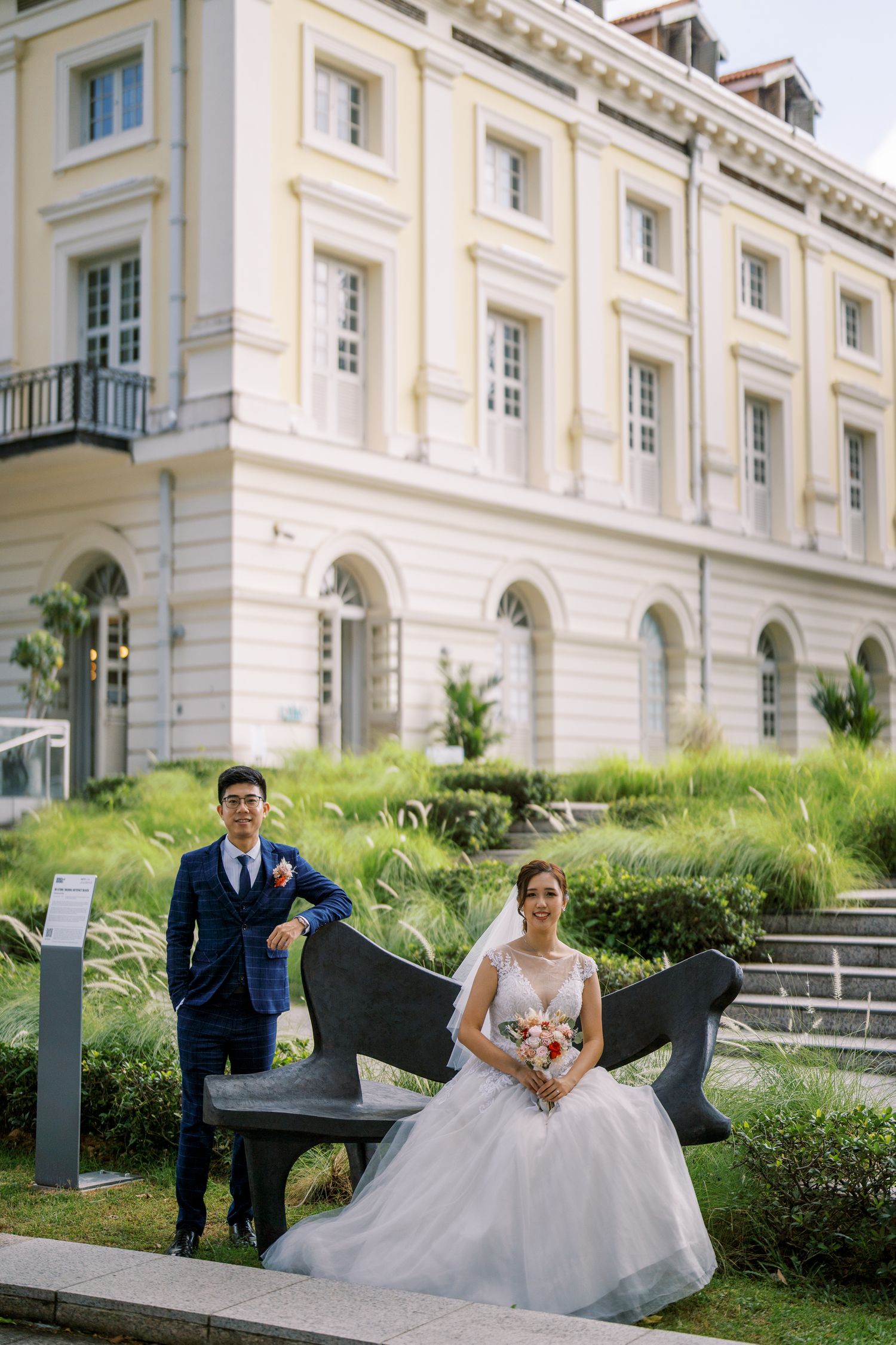 Elegant white building with manicured lawn and architectural details in daylight.