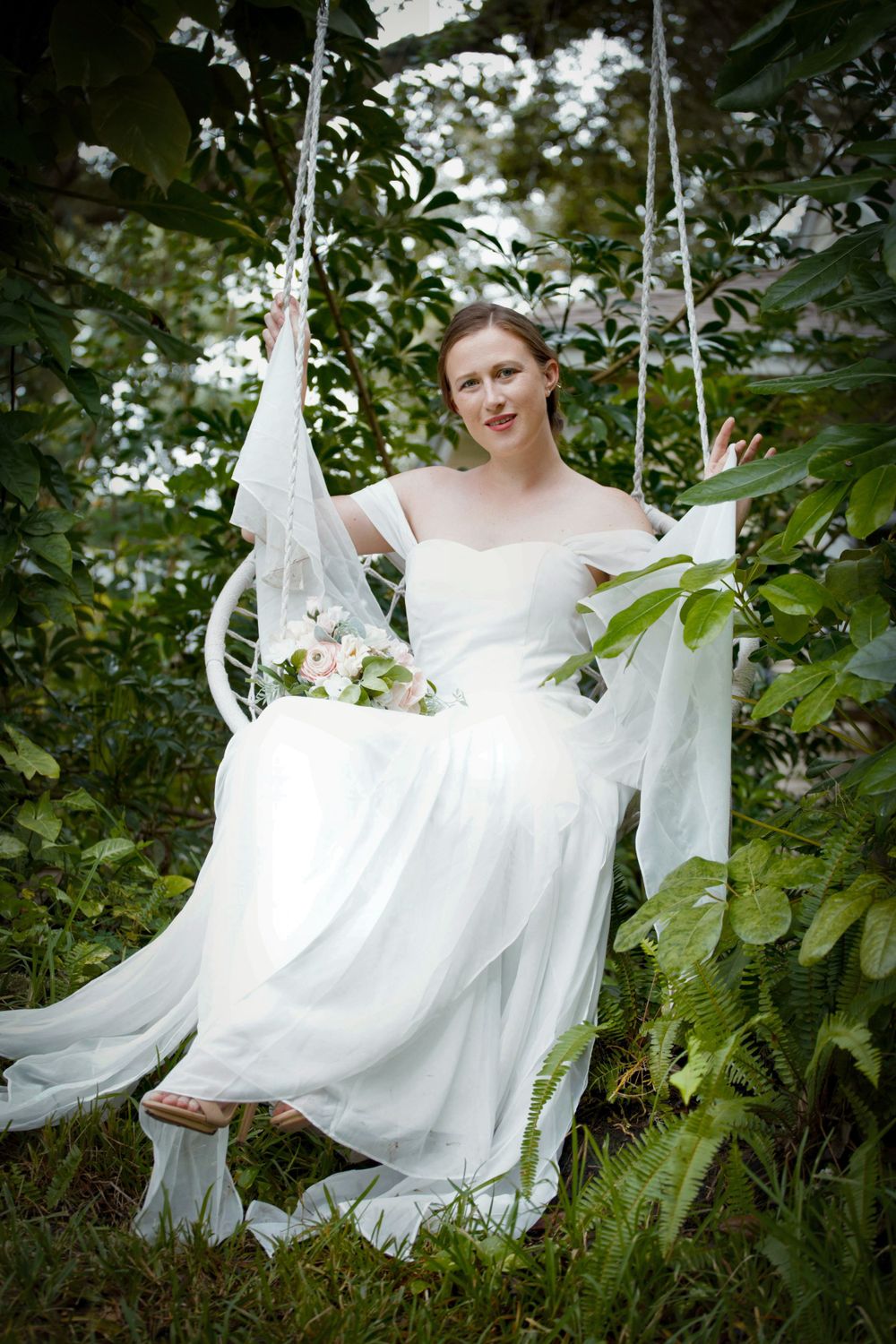 A Bride sitting on a fancy swing.