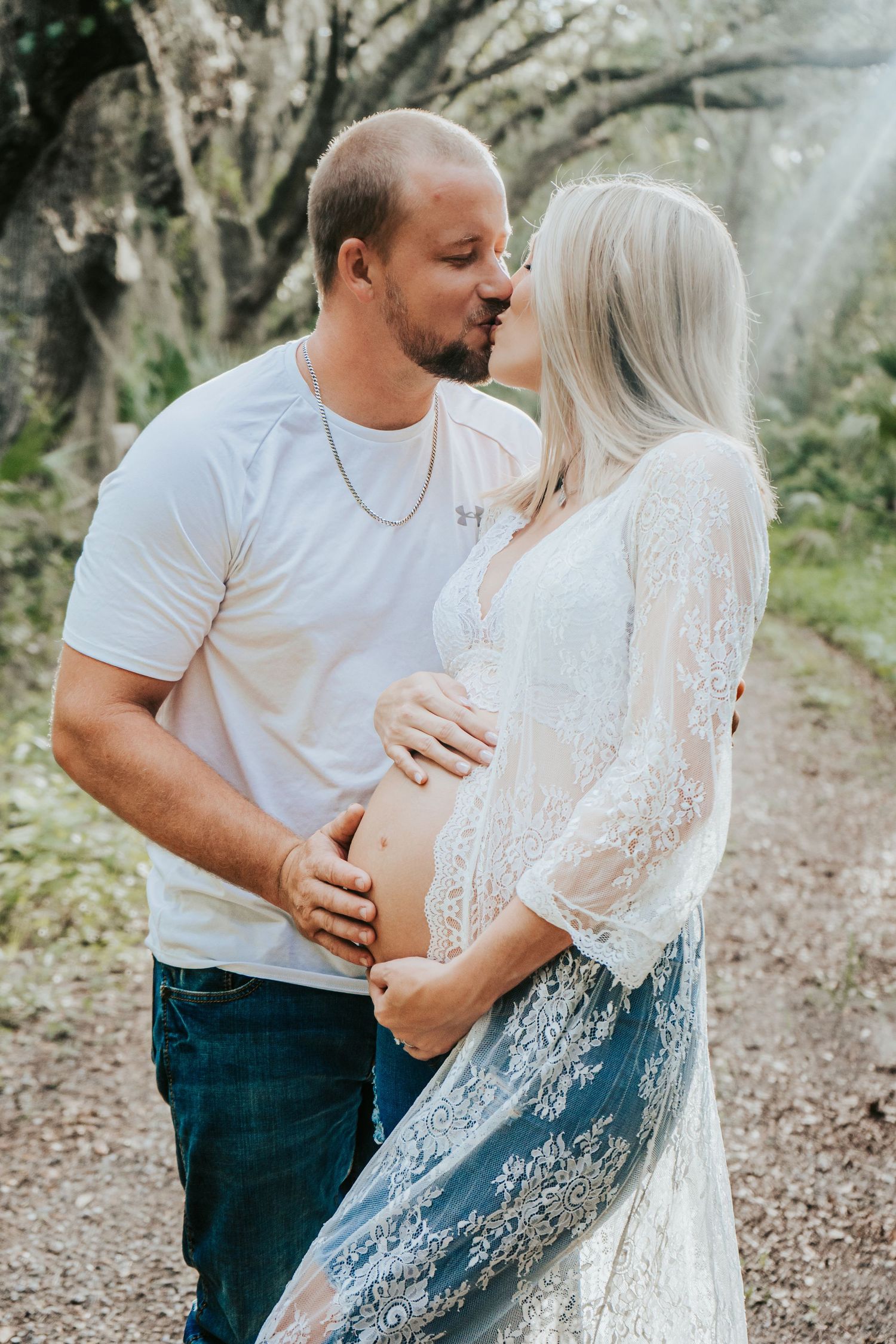 Outdoor Maternity Session at Thatcher Park, Lithia, FL; husband kissing pregnant wife bathed in sunlight