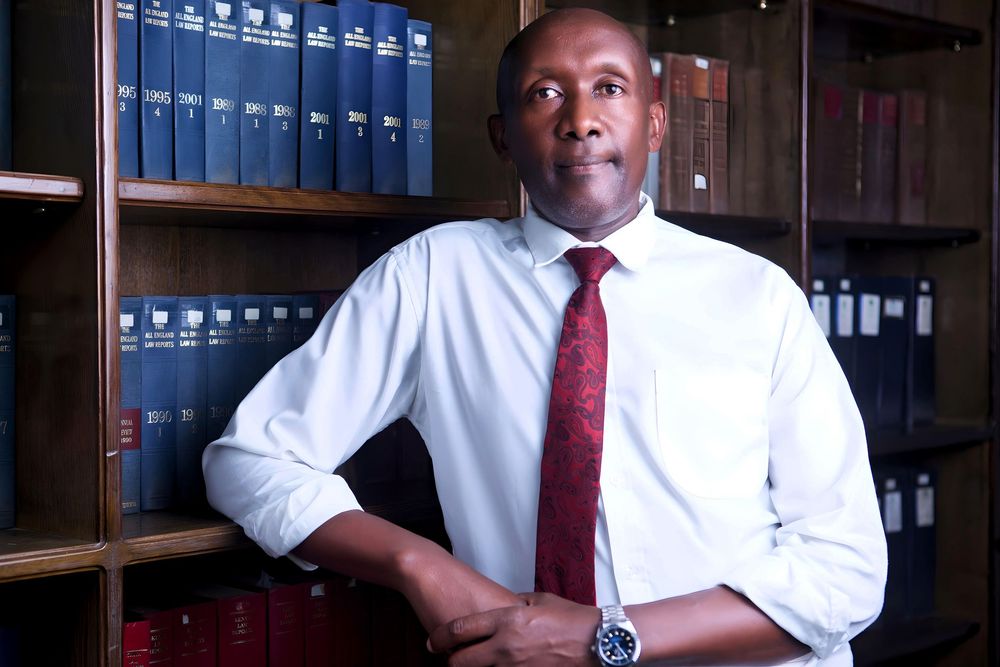 Lawyer in white shirt and red tie photographed in library setting.