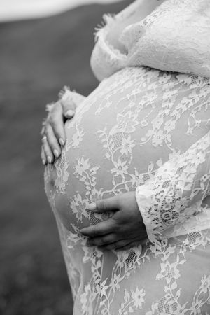 Detail shots of intricate white lace pattern on maternity dress.
