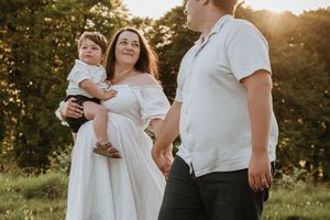 Family shares intimate moments together during golden hour in a natural outdoor setting.