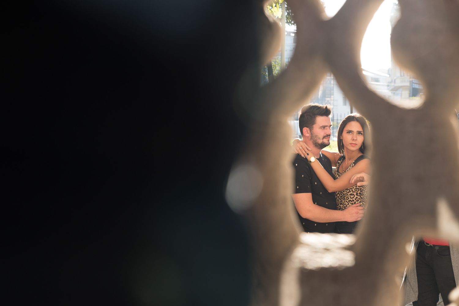 Artistic portrait with bokeh lights creating dreamy atmosphere around embracing couple.