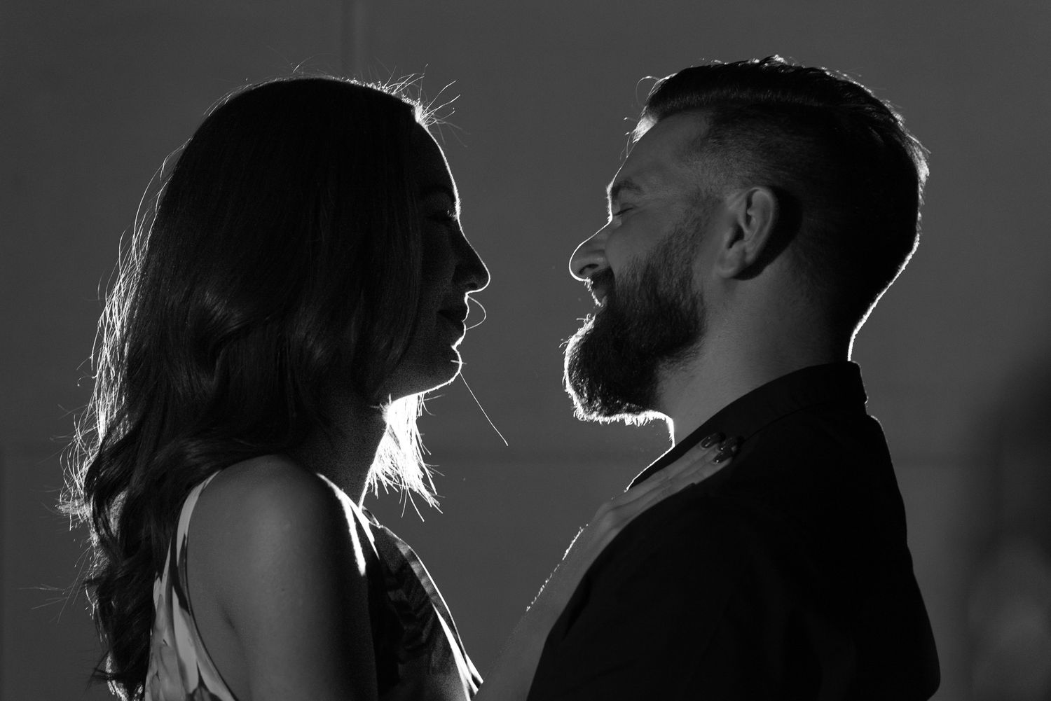 Dramatic black and white profile silhouettes with moody lighting and shadows.
