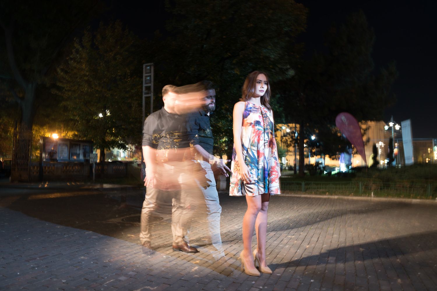 Wedding party walking together at night with illuminated buildings in the background.