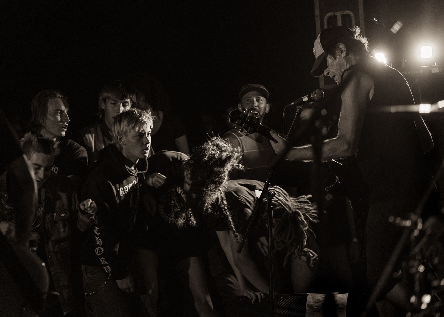 Black and white photo of concert crowd and performer creating an energetic atmosphere.