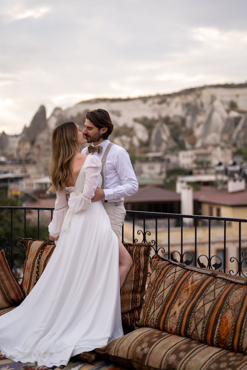 A romantic moment on a balcony overlooking the unique rock formations of Cappadocia.
